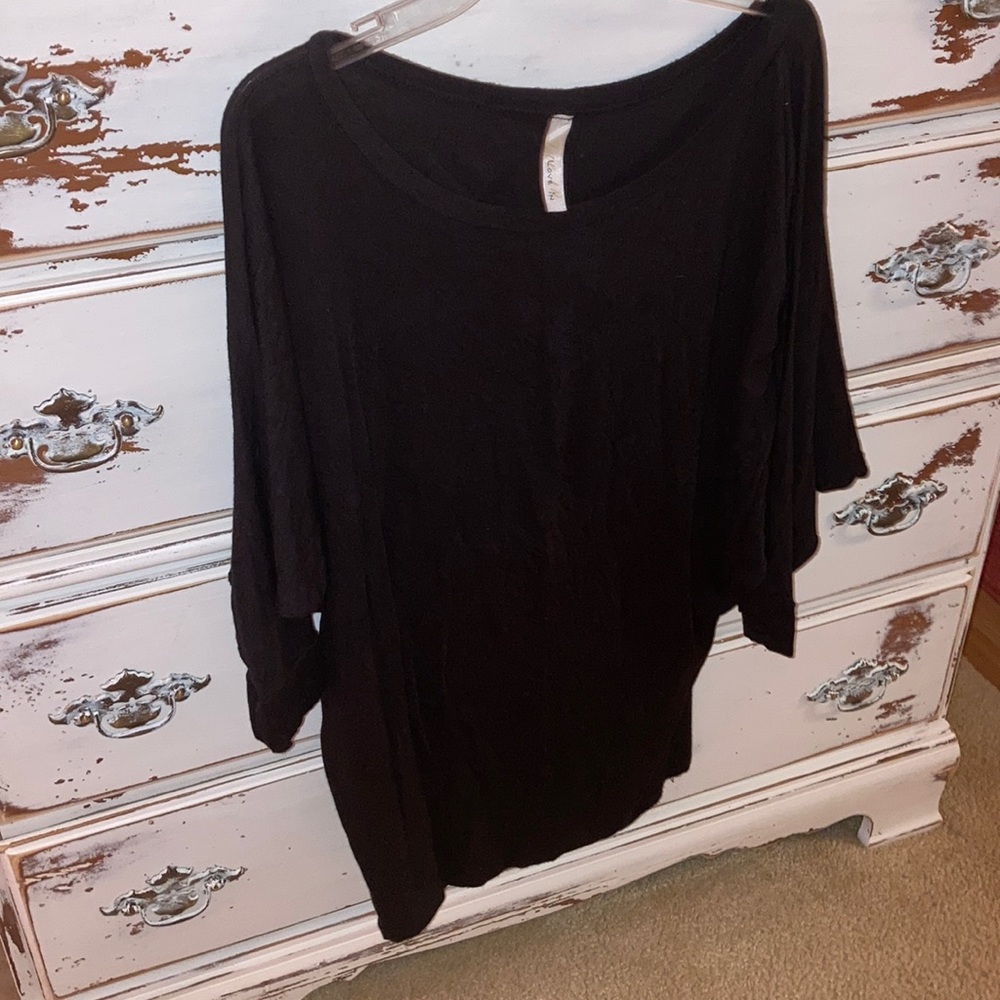 Women’s black blouse with “bat sleeves”.